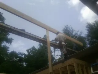 Carpenter setting a ridge beam over a new addition frame — Ice Dam Removal by Roofing Brothers in Huntington Mills