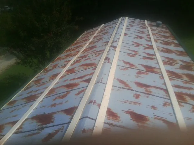 Rusted metal roof panels with new wood purlins before replacement — Storm Damage Roof Repair in Huntington Mills by Roofing Brothers